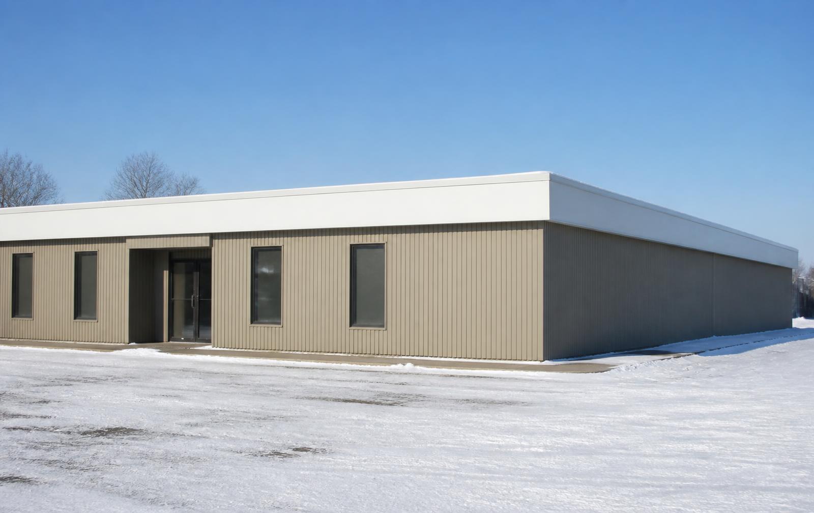 Low commercial flat roofline with a white membrane edge in pale winter light